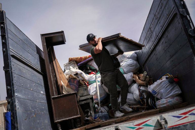 A Syrian man unloads a truck as around 60 displaced families, supported by an NGO, return to their village after more than five years in the Atmeh camps near the Syrian-Turkish border, in Kafr Sijna, south of Idlib, Syria, Sunday, May 18, 2025. (AP Photo/Ghaith Alsayed)