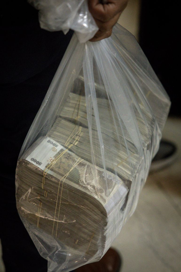 DAMASCUS, SYRIA - DECEMBER 24: A man carries a bag of Syrian pounds after exchanging U.S dollars at the Central Bank Of Syria on December 24, 2024 in Damascus, Syria. On December 8, rebel forces in Syria retook the capital and several other cities from longtime ruler Bashar al-Assad, who fled the country for Moscow. The fall of the Assad regime marks a new chapter for Syria, which has been mired in a multi-party civil war since 2011, sparked by the Arab Spring uprisings. (Photo by Chris McGrath/Getty Images)