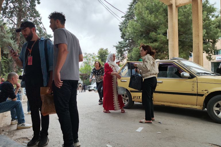 ذوو مصابين ينتظرون أخباراً عن أبنائهم من أمام مستشفى السويداء (الجزيرة نت)