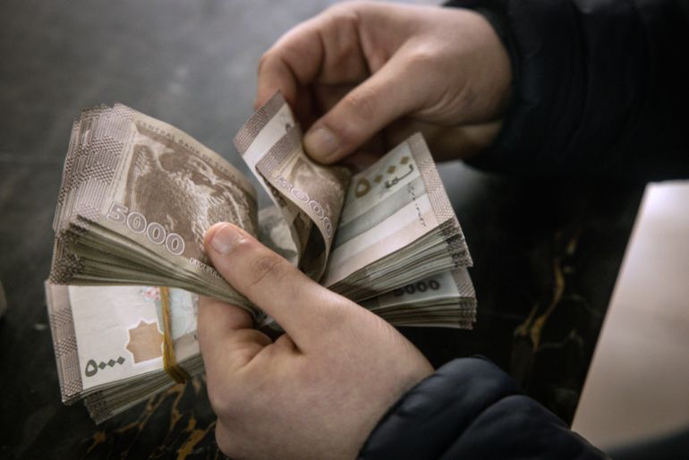 DAMASCUS, SYRIA - DECEMBER 24: A man counts Syrian pounds after exchanging U.S dollars at the Central Bank Of Syria on December 24, 2024 in Damascus, Syria. On December 8, rebel forces in Syria retook the capital and several other cities from longtime ruler Bashar al-Assad, who fled the country for Moscow. The fall of the Assad regime marks a new chapter for Syria, which has been mired in a multi-party civil war since 2011, sparked by the Arab Spring uprisings. (Photo by Chris McGrath/Getty Images)